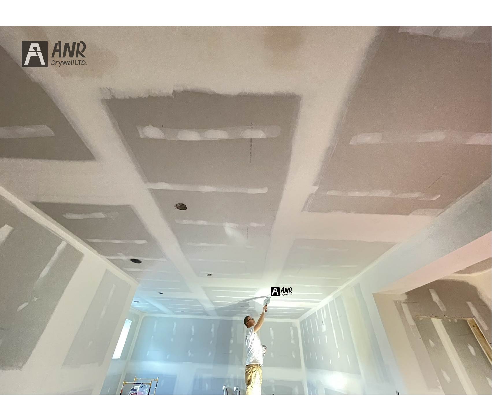 Technicians from ANR Drywall LTD are installing drywall boards in a client's basement.