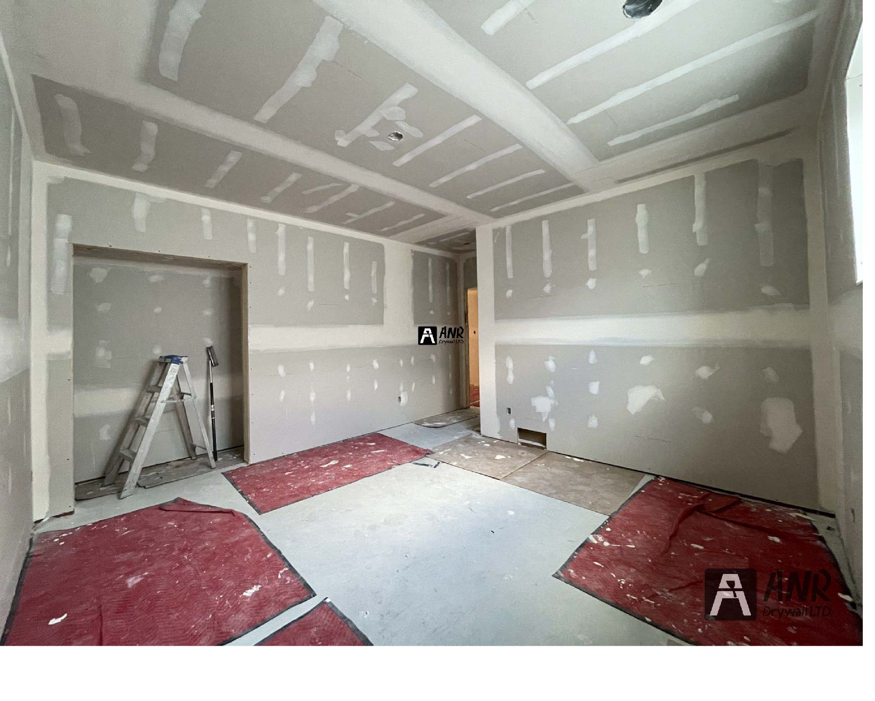 Technicians from ANR Drywall LTD are installing drywall boards in a client's basement.