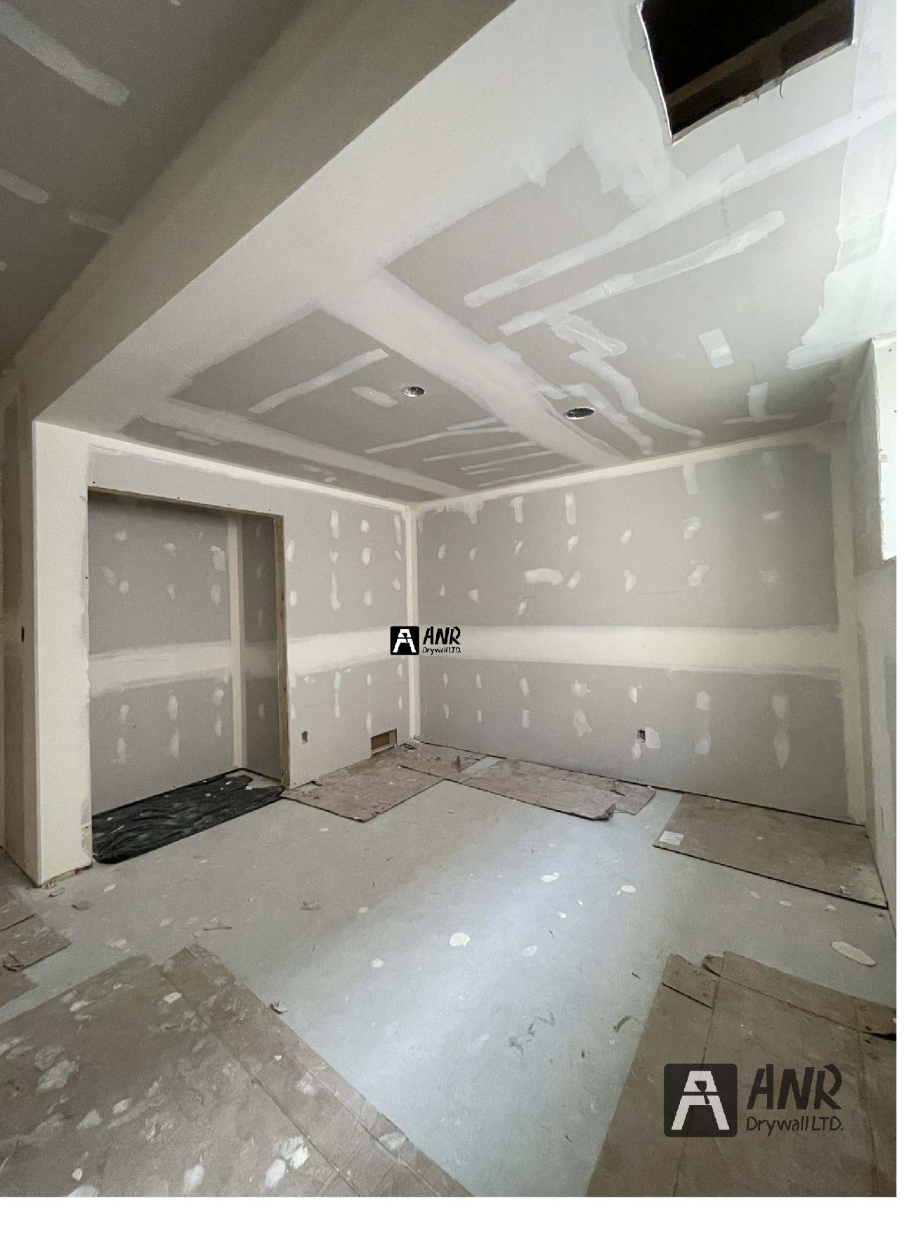 Technicians from ANR Drywall LTD are installing drywall boards in a client's basement.