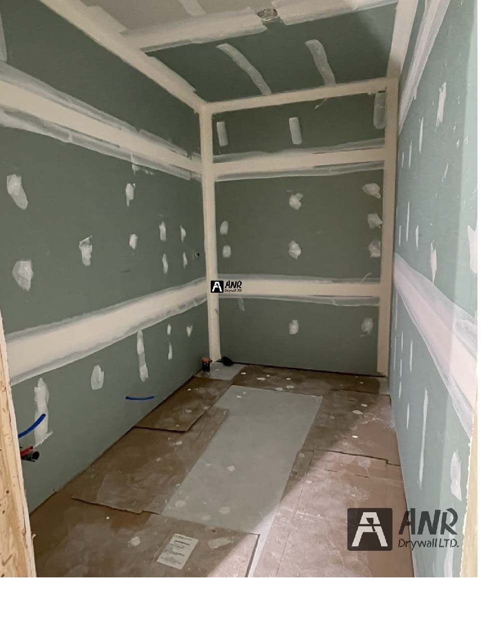 Technicians from ANR Drywall LTD are installing drywall boards in a client's basement.