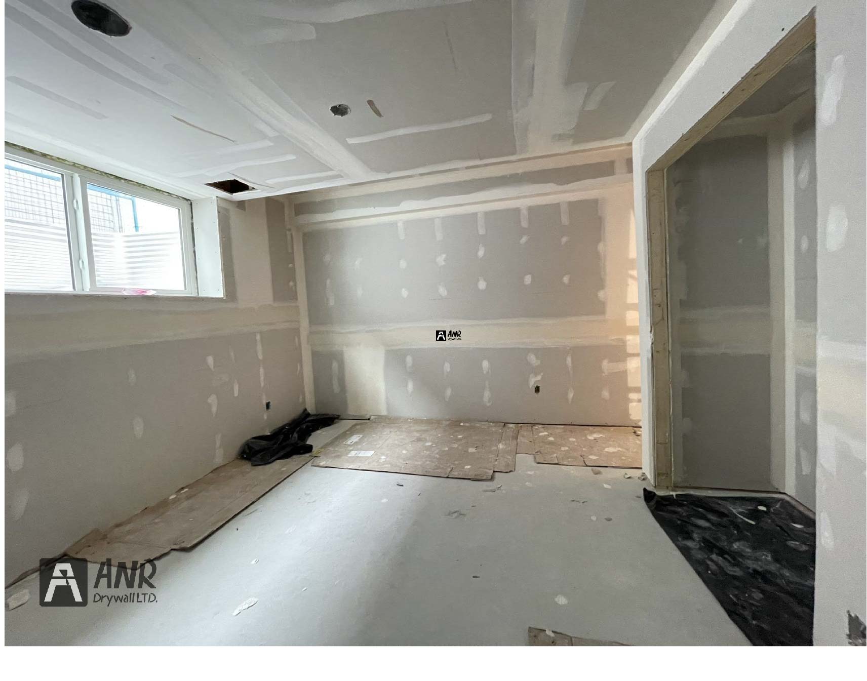 Technicians from ANR Drywall LTD are installing drywall boards in a client's basement.