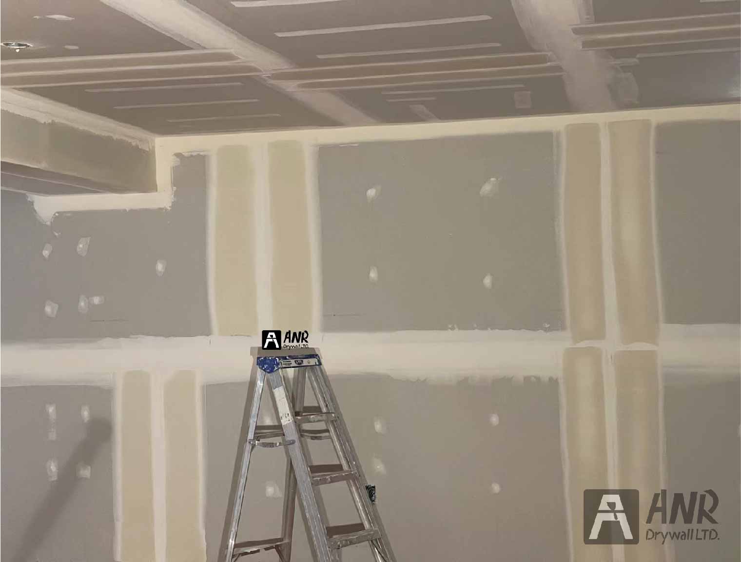 Technicians from ANR Drywall LTD are installing drywall boards in a client's basement.