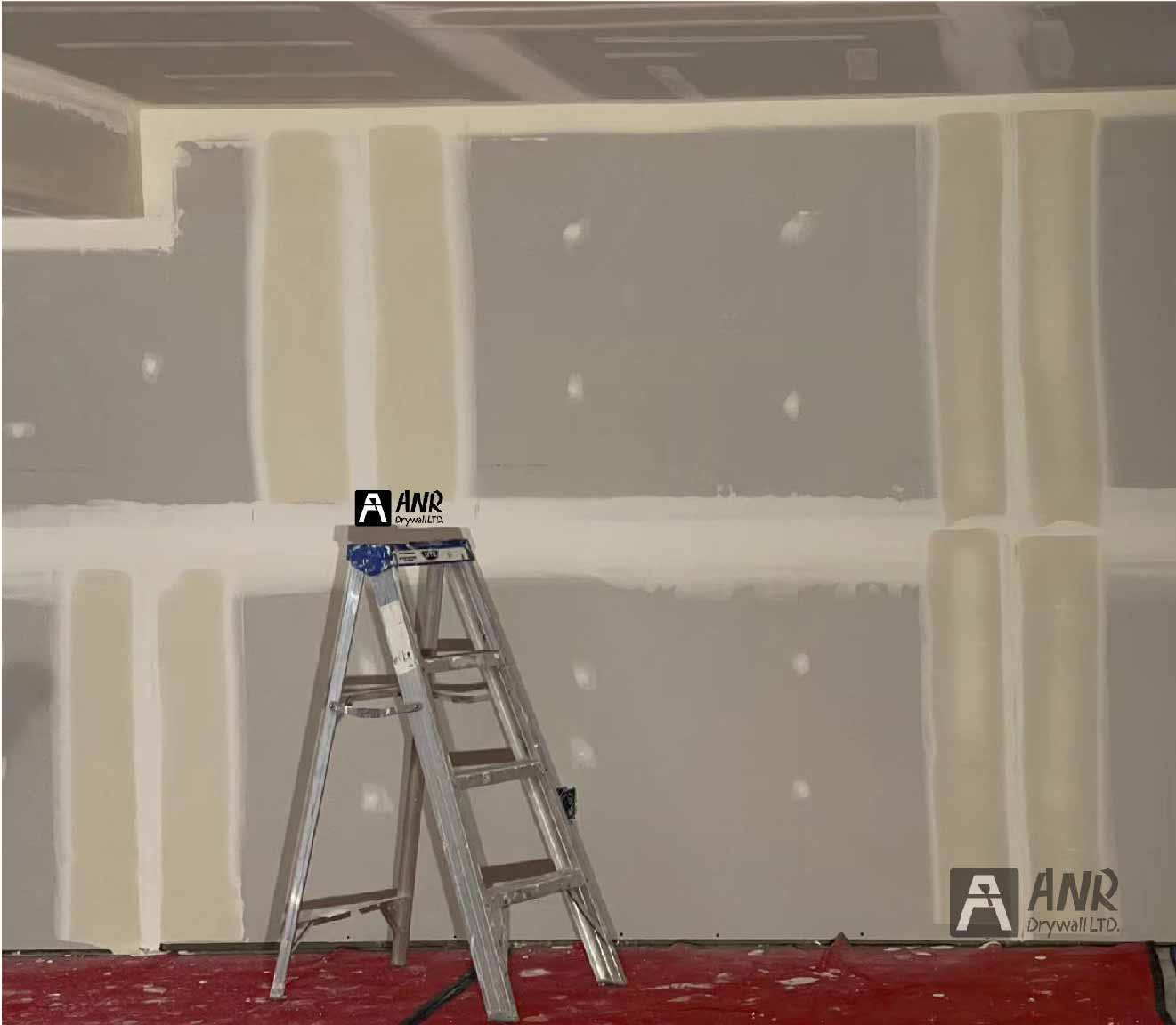 Technicians from ANR Drywall LTD are installing drywall boards in a client's basement.